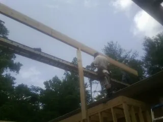 Carpenter setting a ridge beam over a new addition frame — Ice Dam Removal by Roofing Brothers in Hilmar