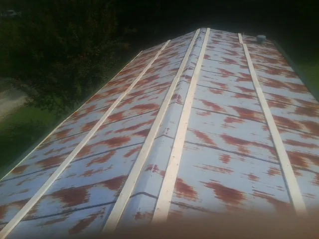 Rusted metal roof panels with new wood purlins before replacement — Storm Damage Roof Repair in Hilmar by Roofing Brothers