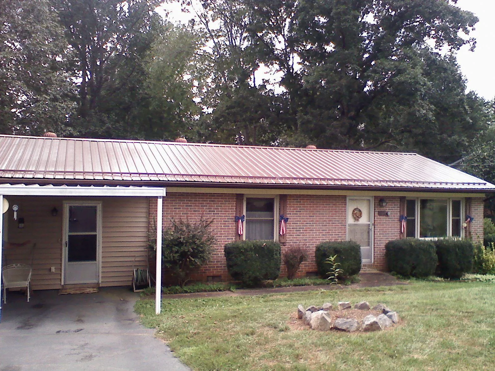 Bronze metal roof and carport on a brick ranch home — Roof Repair work by our crew in Hilmar